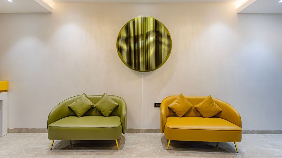 Lemonridge Hotels, KPHB | Lobby seating area with a yellow loveseat and decorative wall art. Modern and inviting space.
